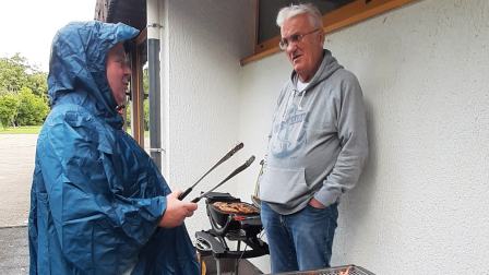 Mitglieder des Filmkreis-Langenfeld stehen am Grill.